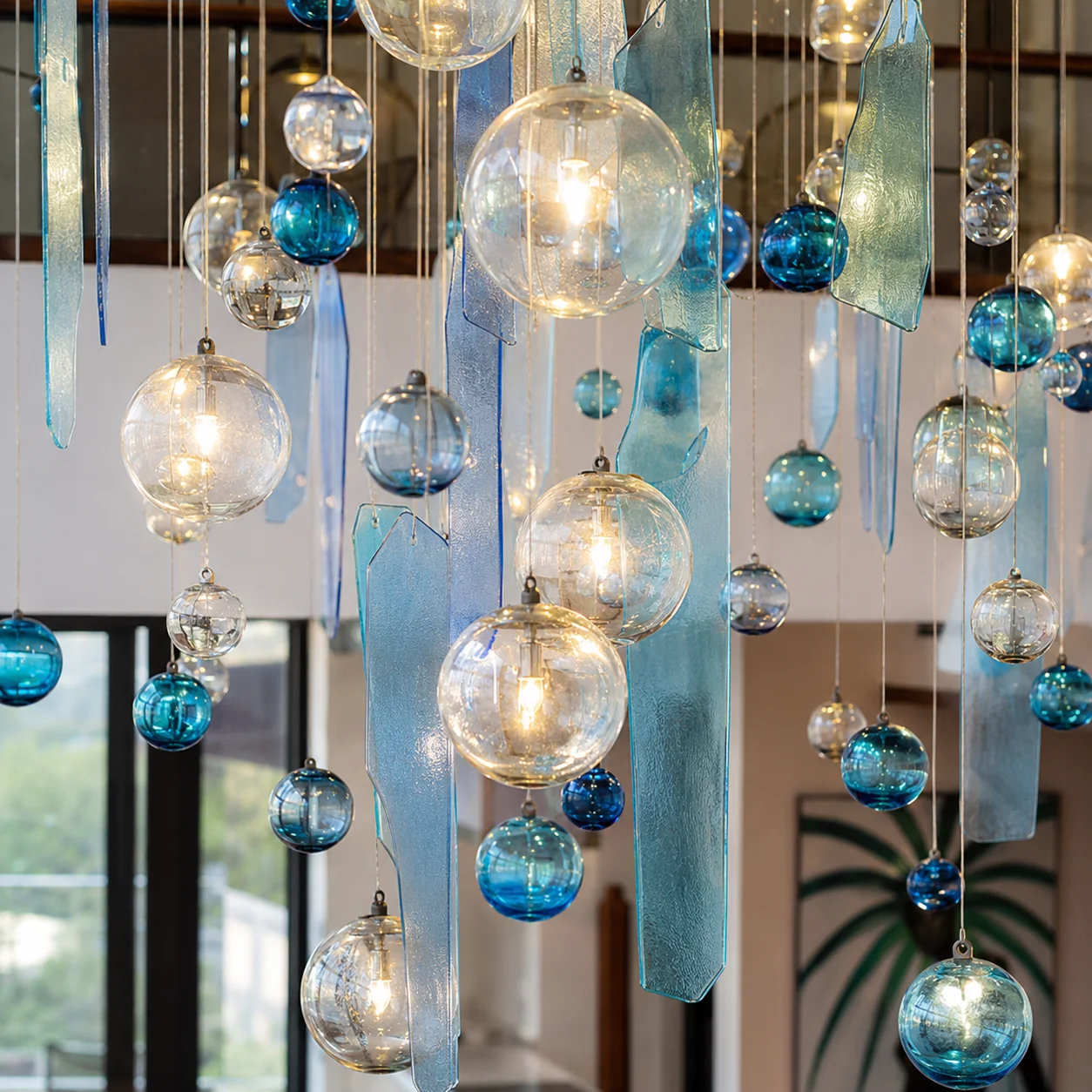 Close view of suspended blue glass panels and illuminated glass globes