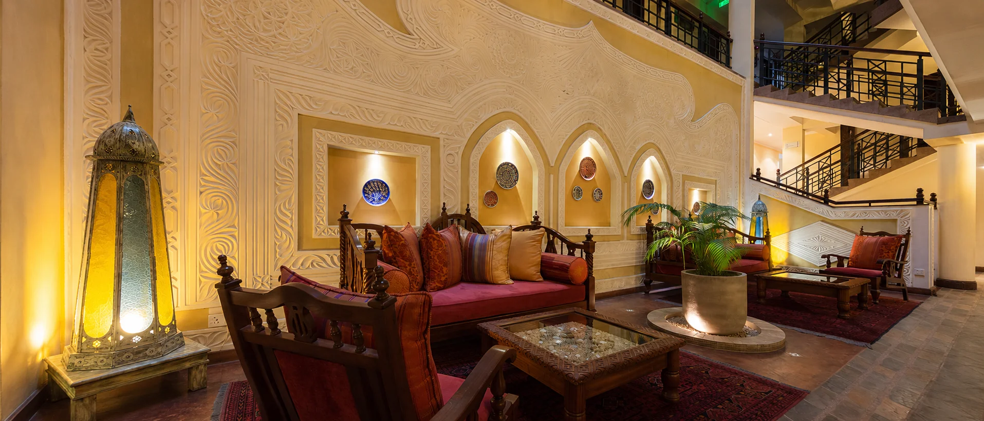 Heron Hotel lounge with carved plaster walls, timber seating and decorative lanterns