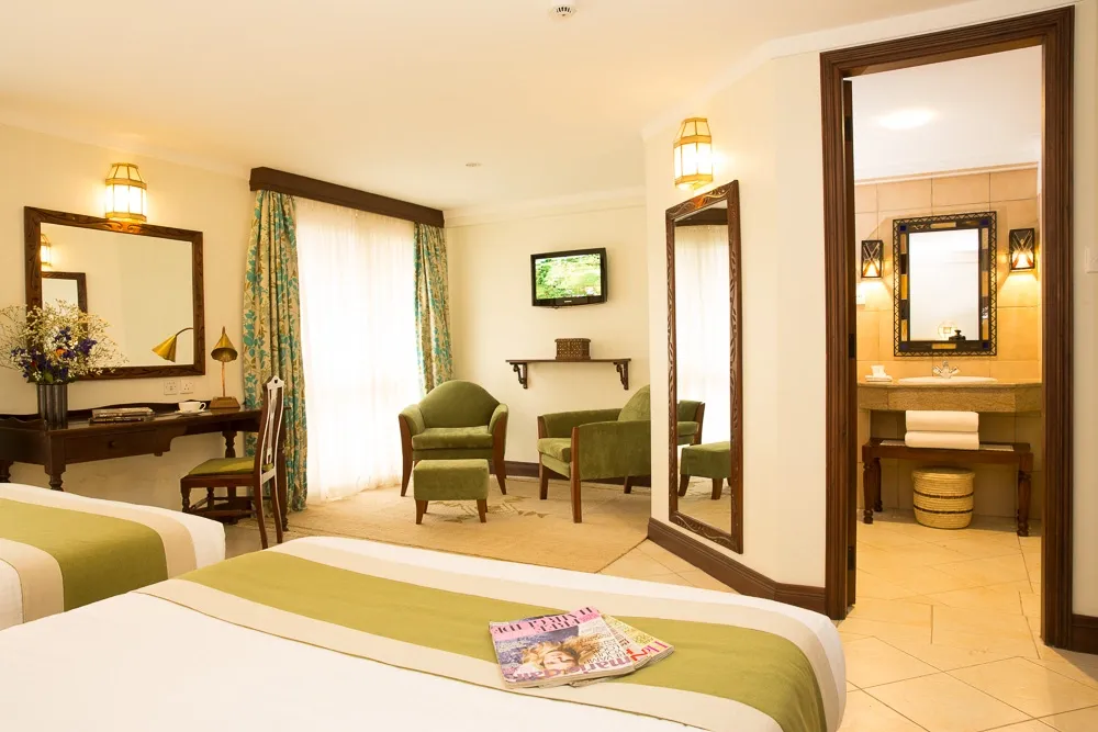 Twin beds with patterned bed runners — Heron Portico Hotel