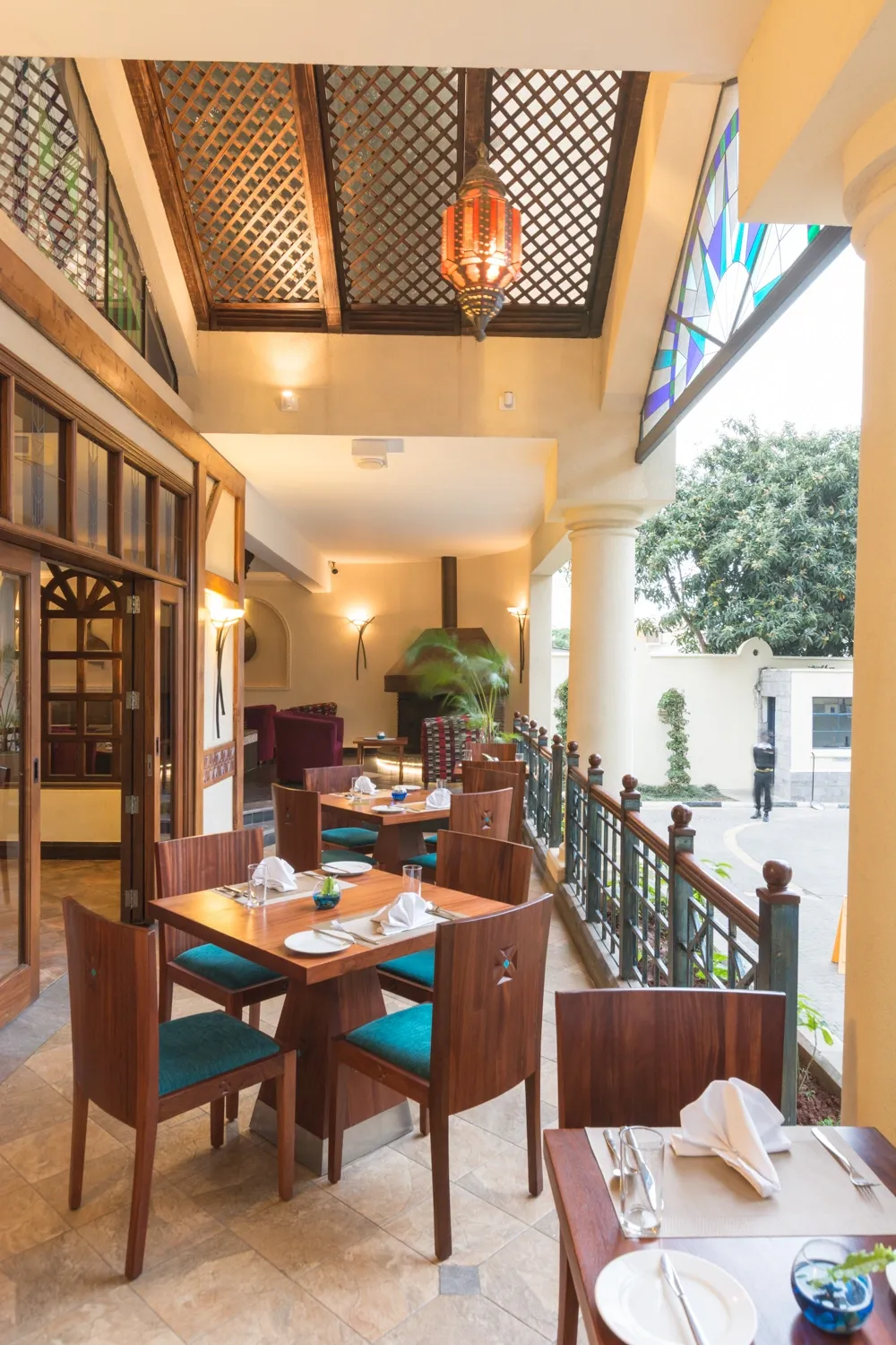 Covered dining veranda with timber furniture — Heron Portico Hotel