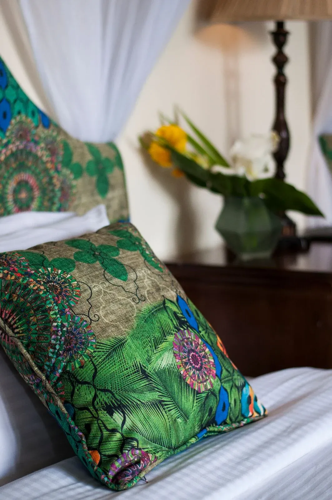 Green patterned cushion and draped bed at The Bishops House