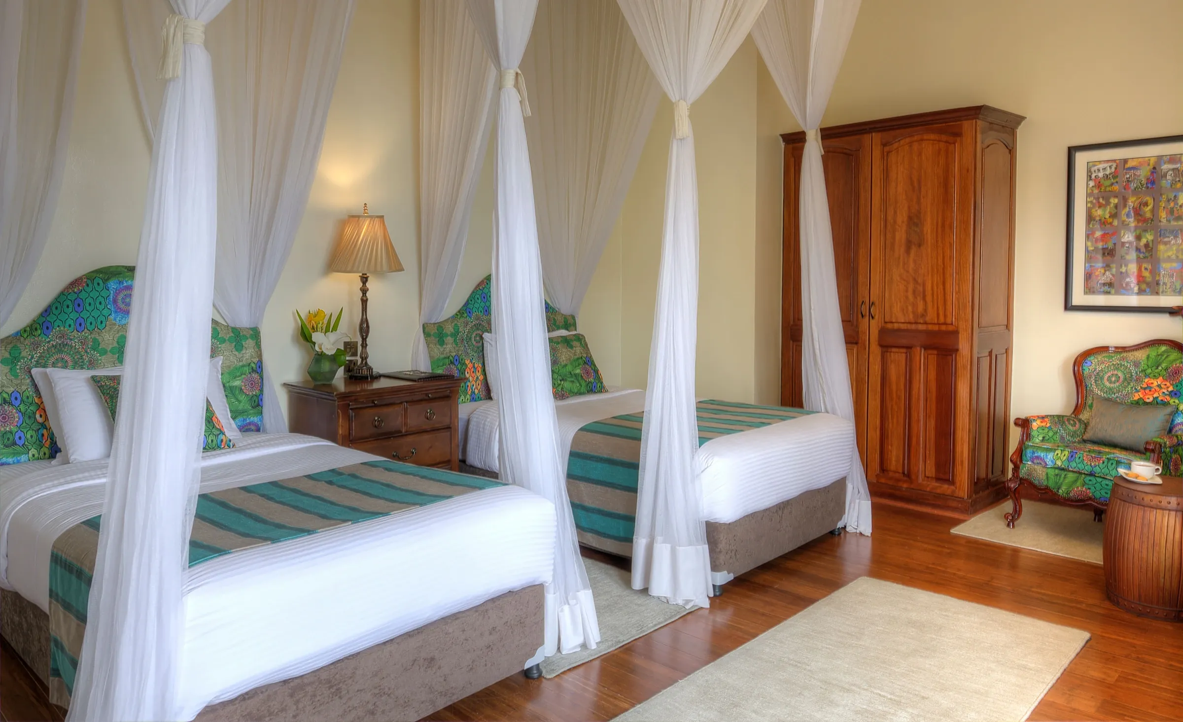 The Bishops House bedroom with two draped beds, patterned green headboards and timber furniture