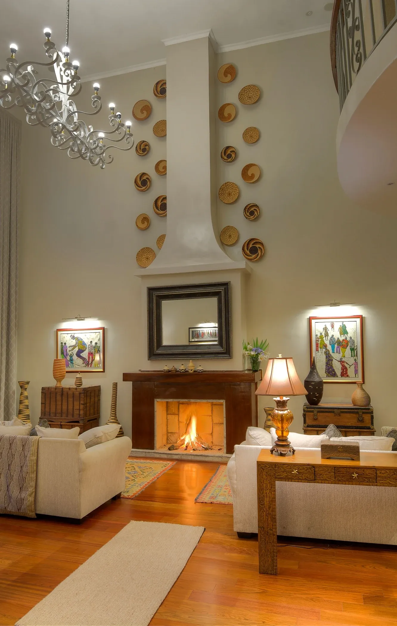 Double-height lounge with a fireplace, framed artwork and upholstered seating