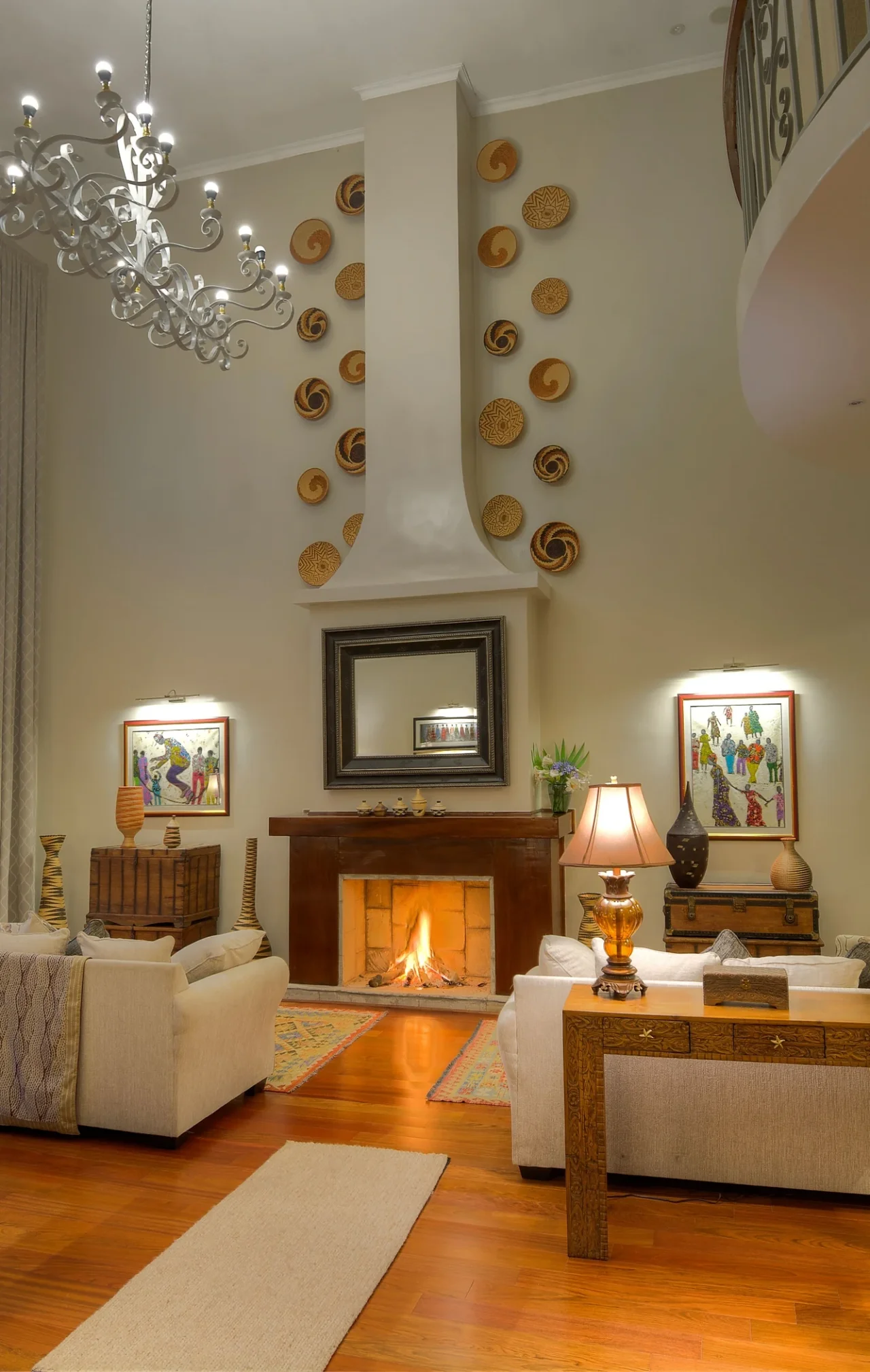 Double-height lounge with a fireplace, framed artwork and upholstered seating