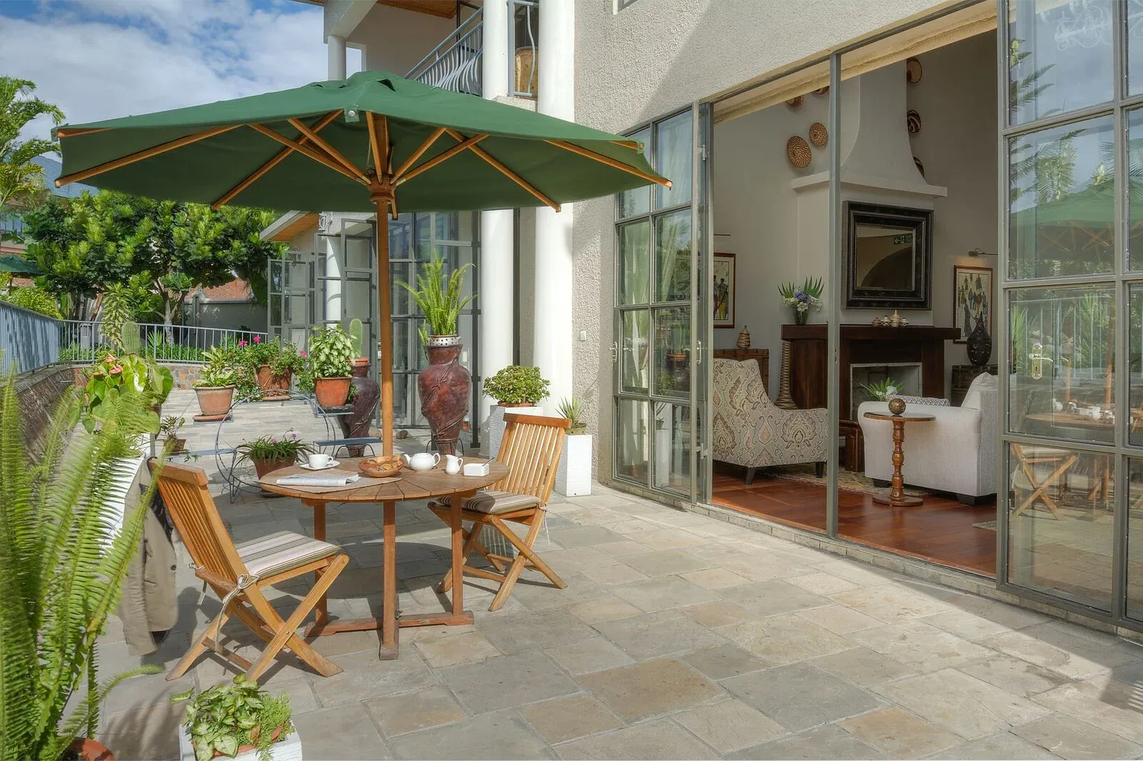 Terrace seating beneath a green parasol at The Bishops House