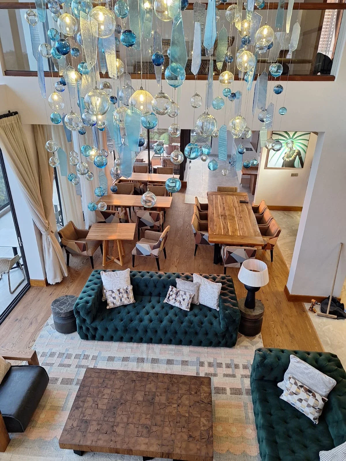 View down into the Sky Villa Soleil lounge beneath suspended glass lights