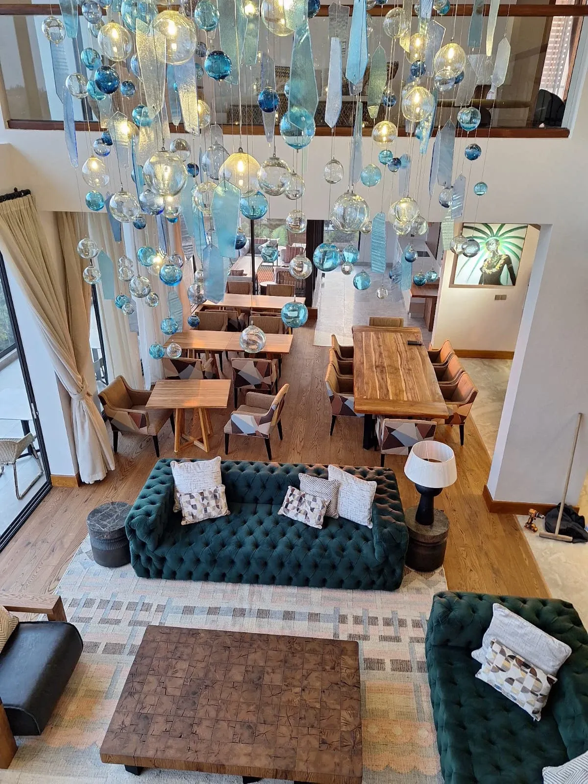 View down into the Sky Villa Soleil lounge beneath suspended glass lights