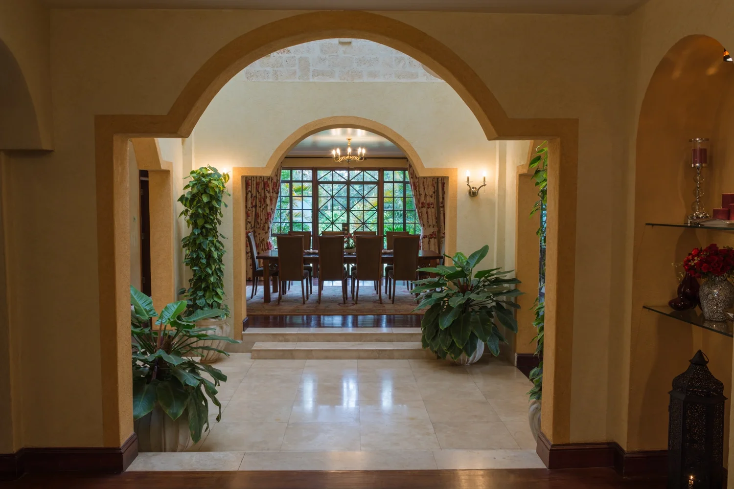 Stone flooring meeting timber, with warm textured walls and archways in Mbogani.
