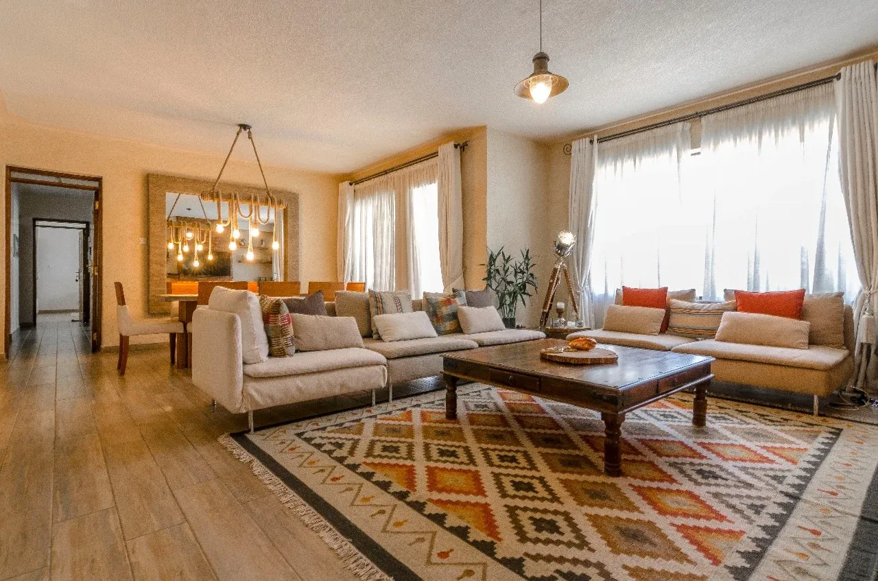 Westlands living room with neutral sofas, orange cushions and a patterned rug