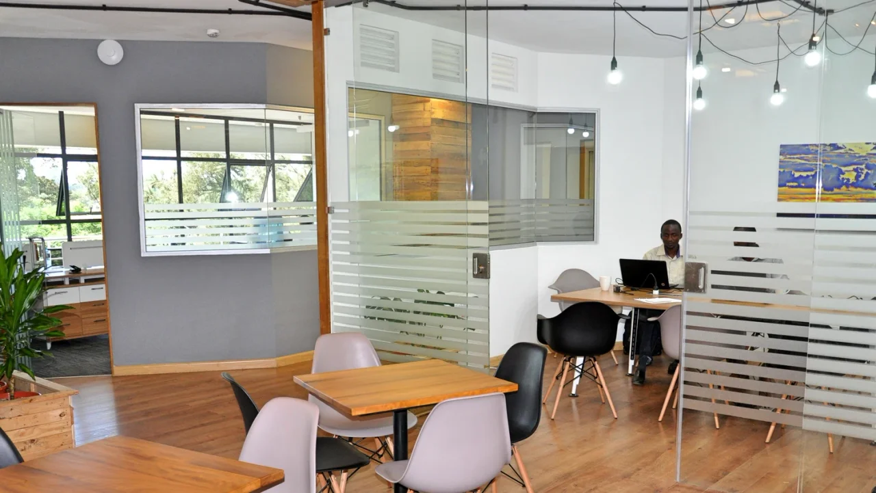 Sustainet workspace with glass meeting-room partitions and café seating