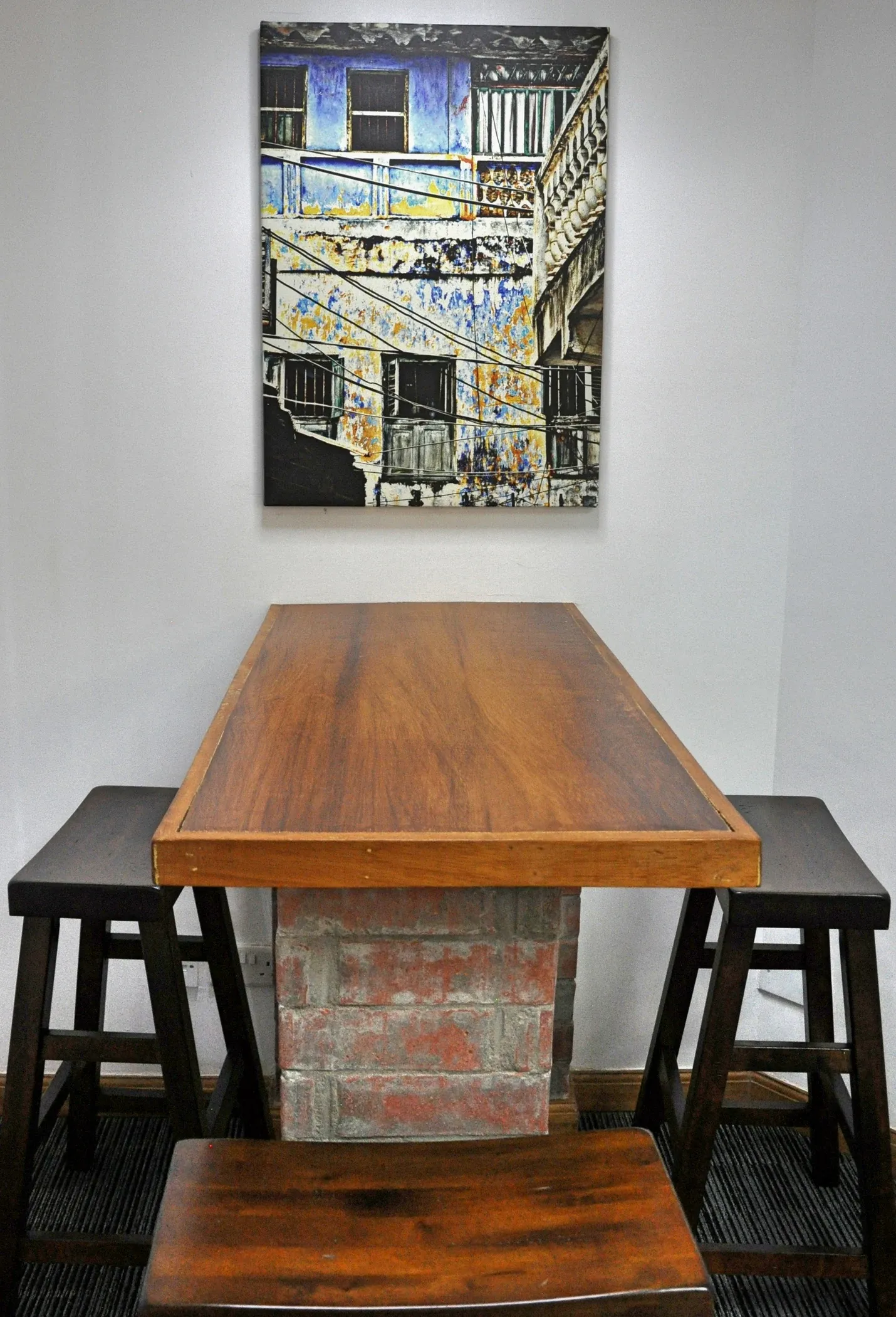 Sustainet meeting room with a timber table, stools and framed artwork